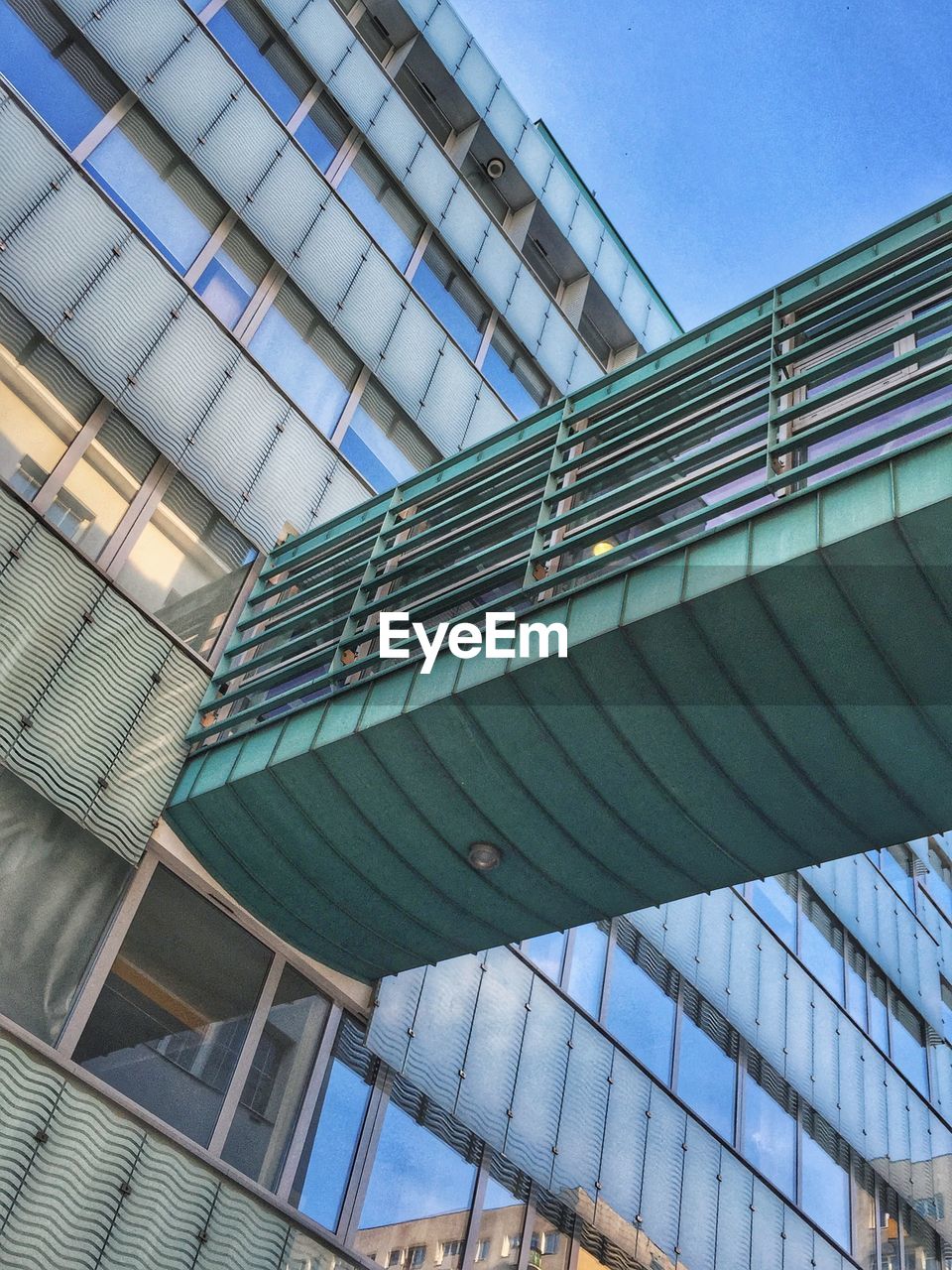 Low angle view of elevated walkway connected to building in city