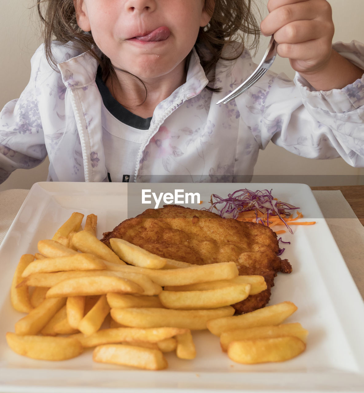 High angle view of girl eating food in plate