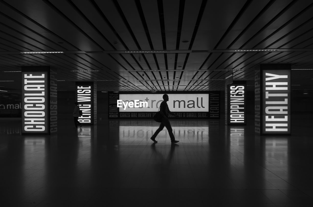 FULL LENGTH OF SILHOUETTE MAN WALKING IN TRAIN