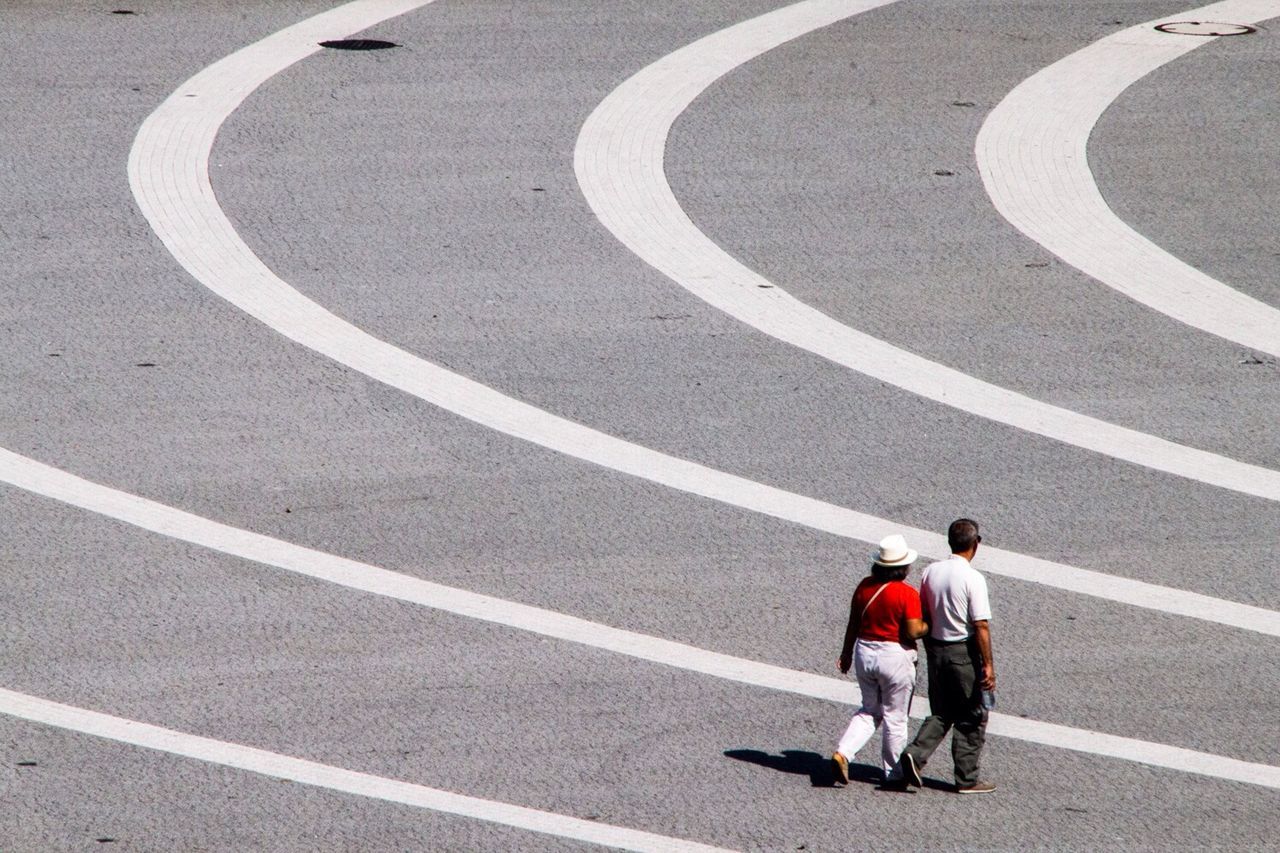 Rear view of couple walking on running track