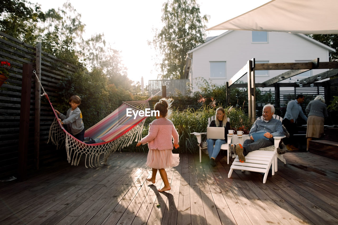 Multi-generation family spending leisure time in backyard during weekend