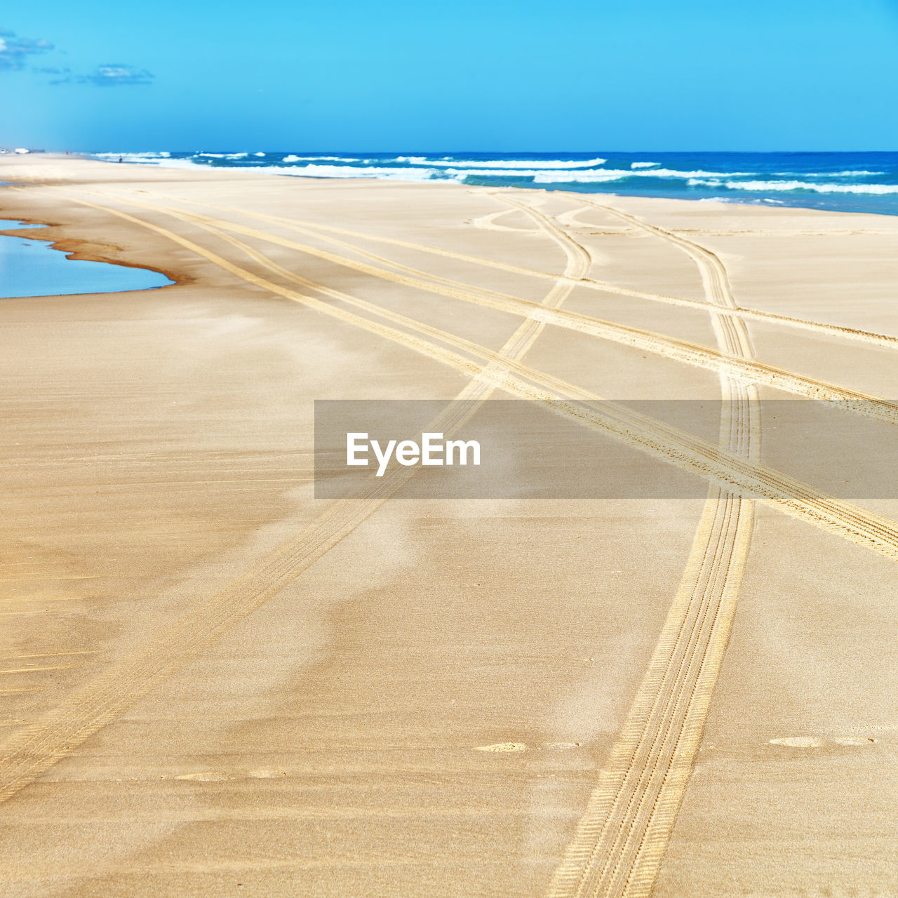 TIRE TRACKS ON SANDY BEACH