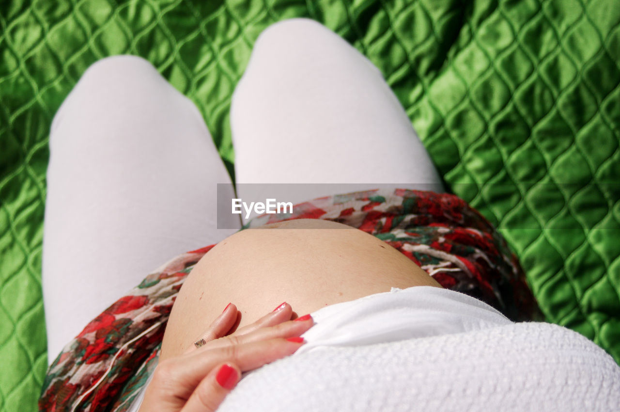 Close-up of pregnant woman holding belly