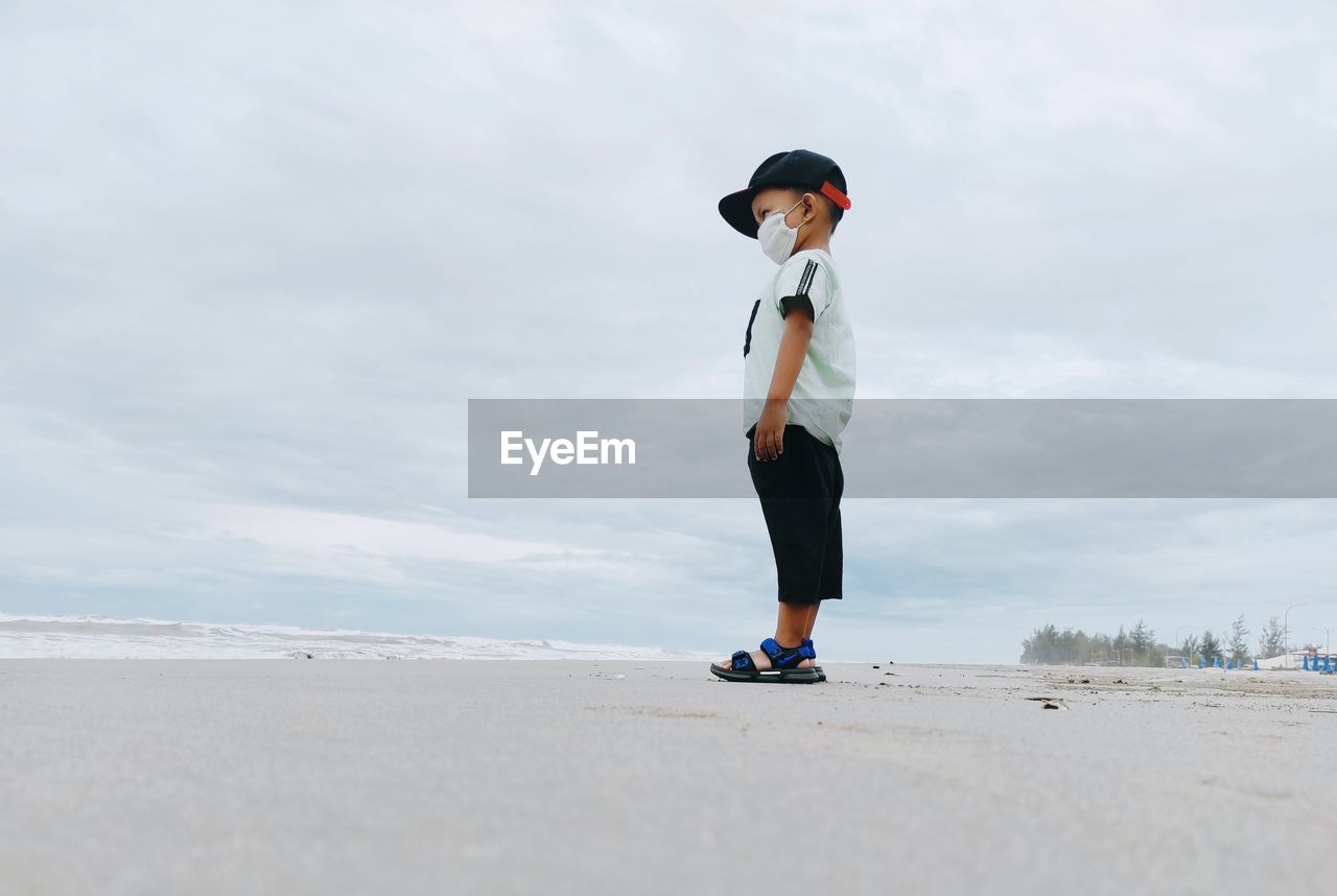 Full length of man standing on beach against sky