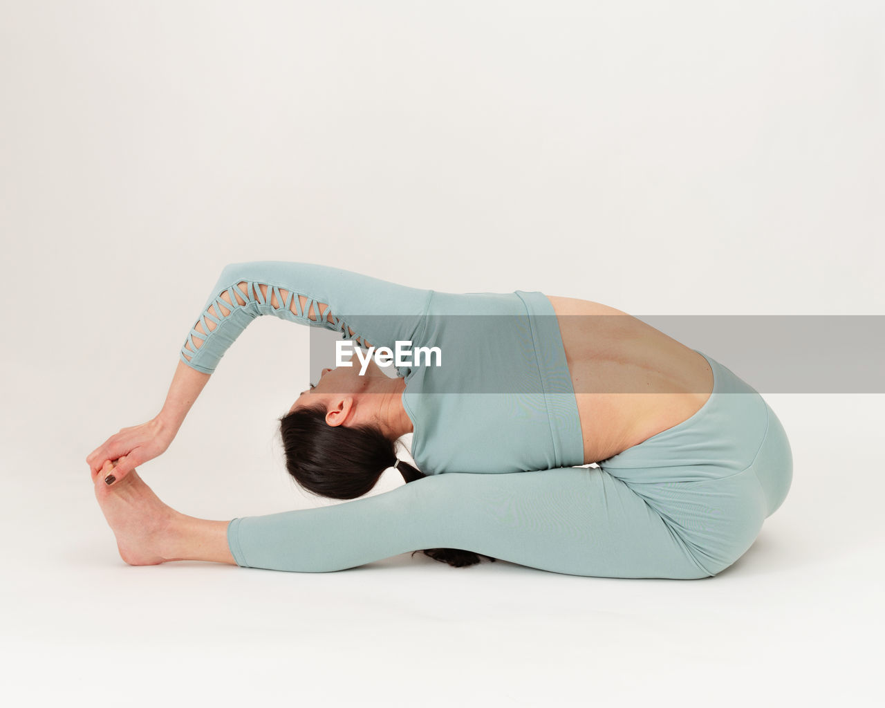 low section of woman exercising on floor against white background