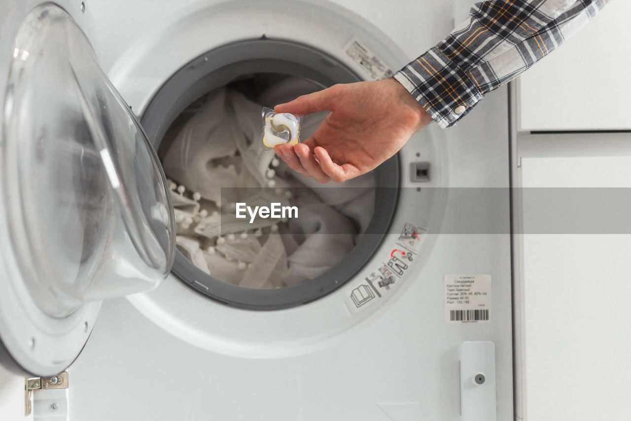 Cropped image of man washing clothes at home