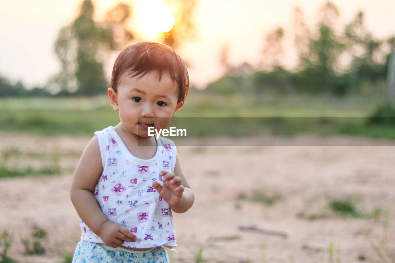 Portrait of cute baby girl standing on land