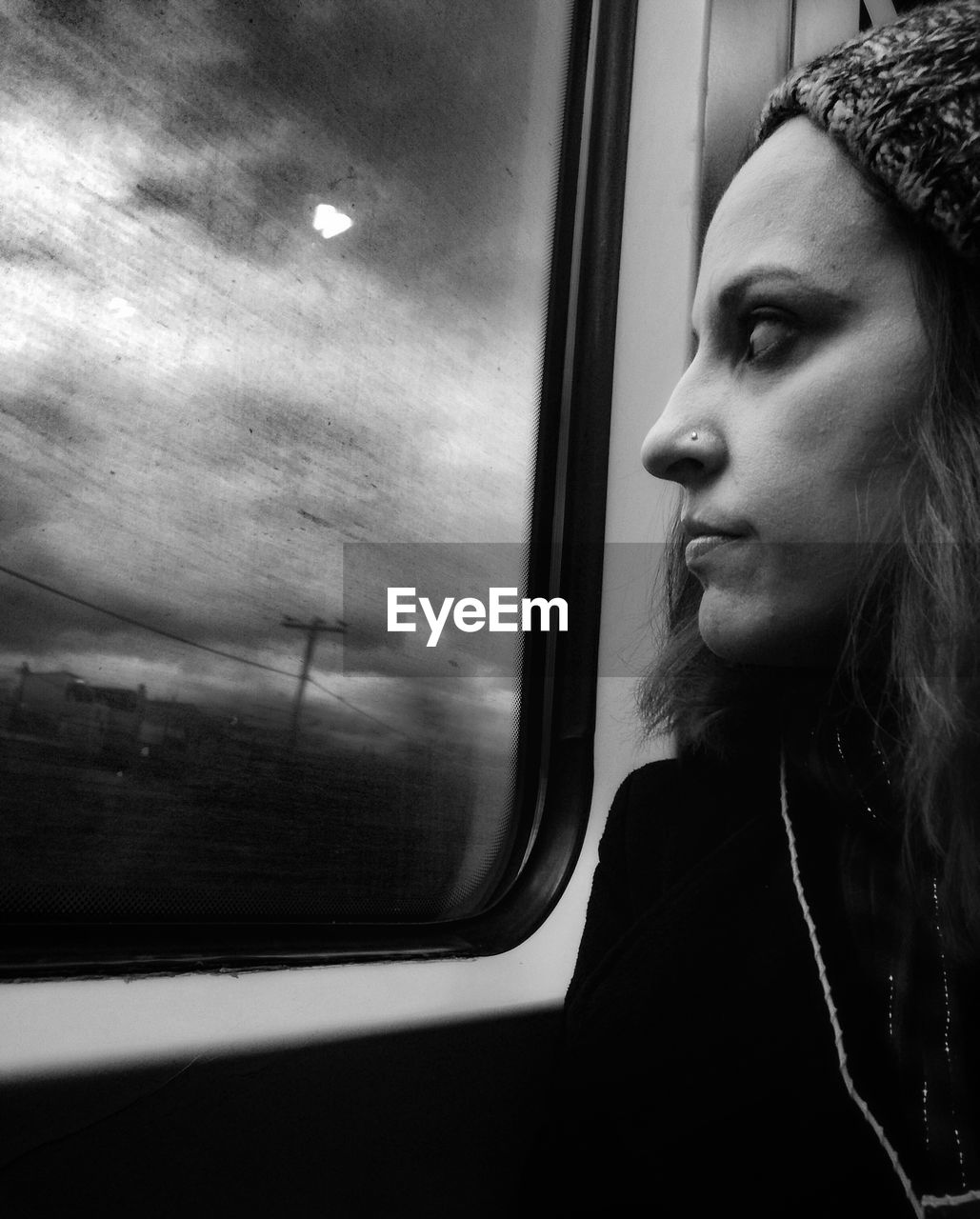 PORTRAIT OF WOMAN LOOKING AT TRAIN WINDOW
