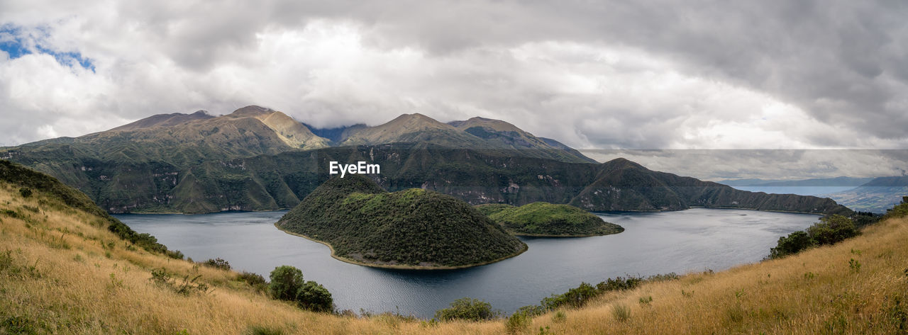 PANORAMIC SHOT OF PLANTS AND MOUNTAINS AGAINST SKY