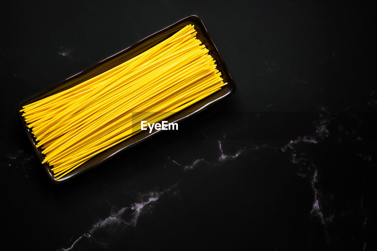 HIGH ANGLE VIEW OF YELLOW FOOD OVER BLACK BACKGROUND
