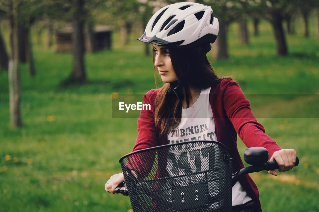 Young woman with bicycle standing on grass