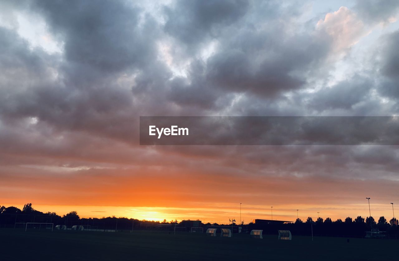 SILHOUETTE LANDSCAPE AGAINST DRAMATIC SKY DURING SUNSET