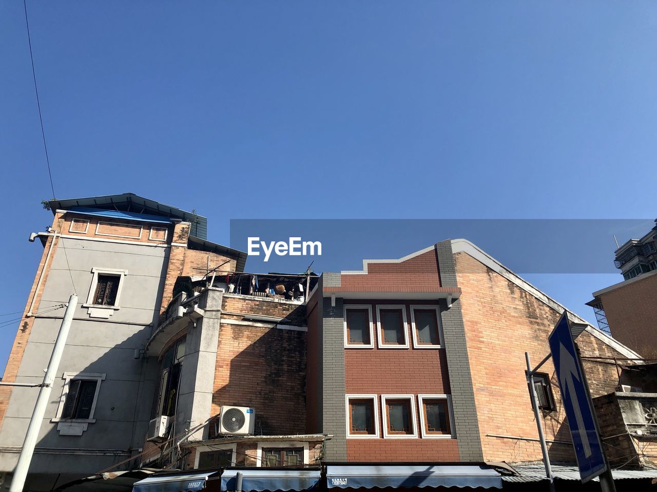 LOW ANGLE VIEW OF BUILDINGS AGAINST BLUE SKY