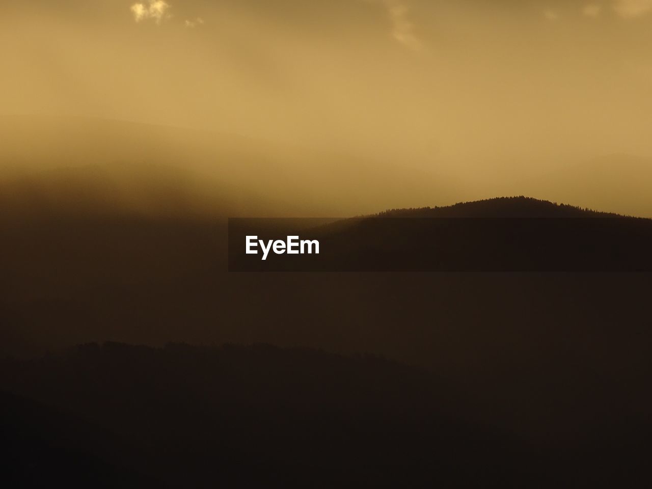 SILHOUETTE OF MOUNTAIN AGAINST SKY AT SUNSET