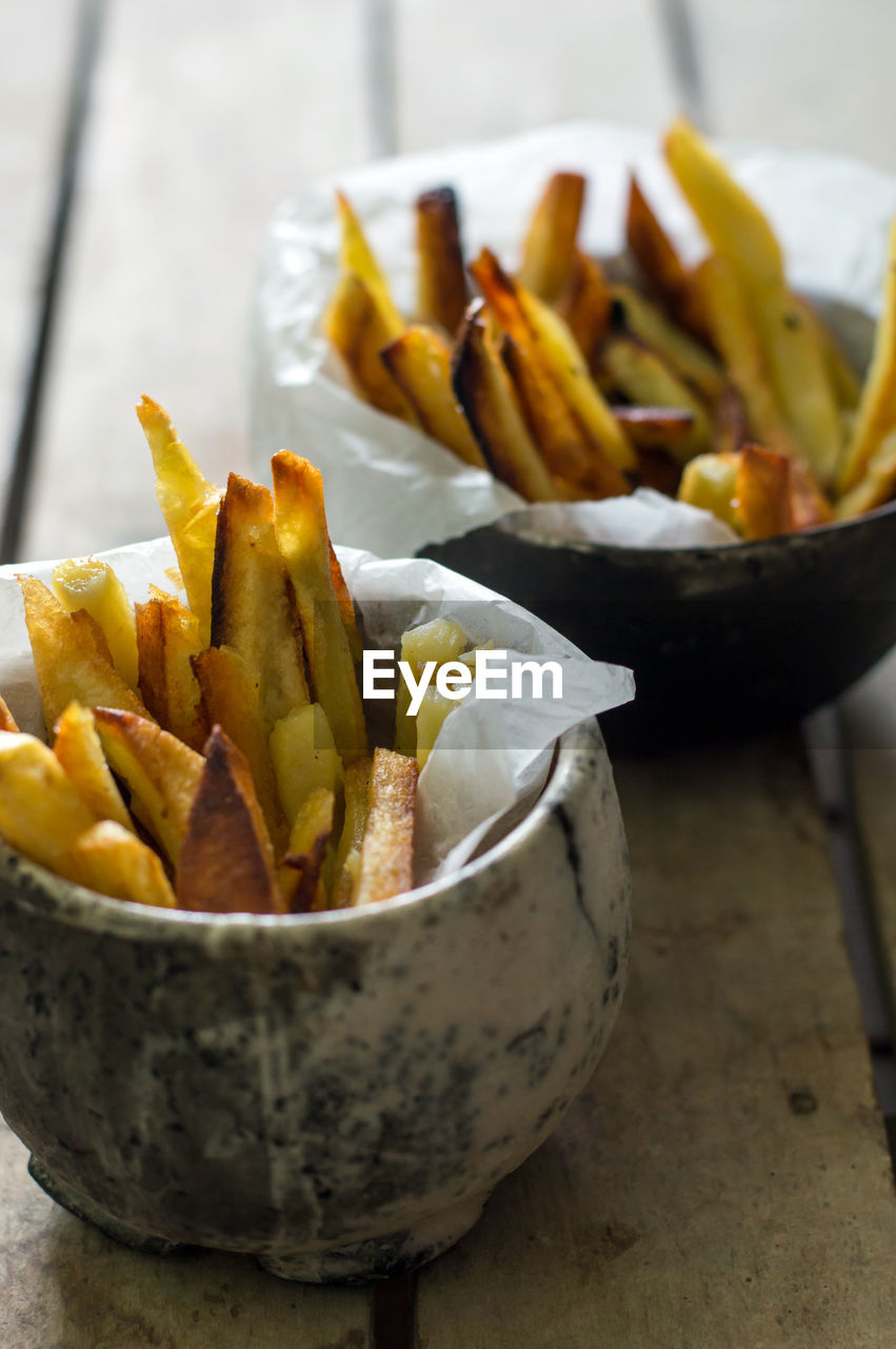 Close-up of french fries in bowls on table