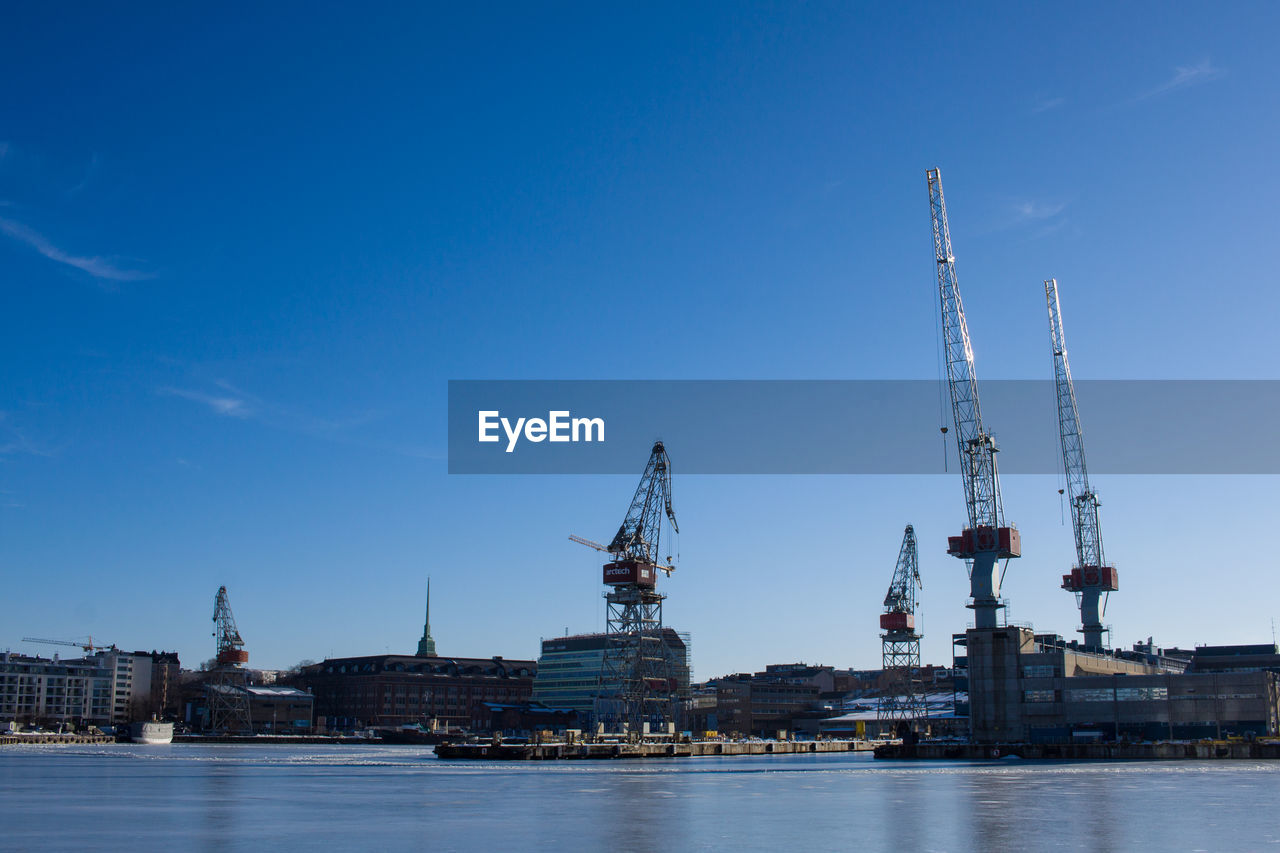 COMMERCIAL DOCK BY RIVER AGAINST SKY