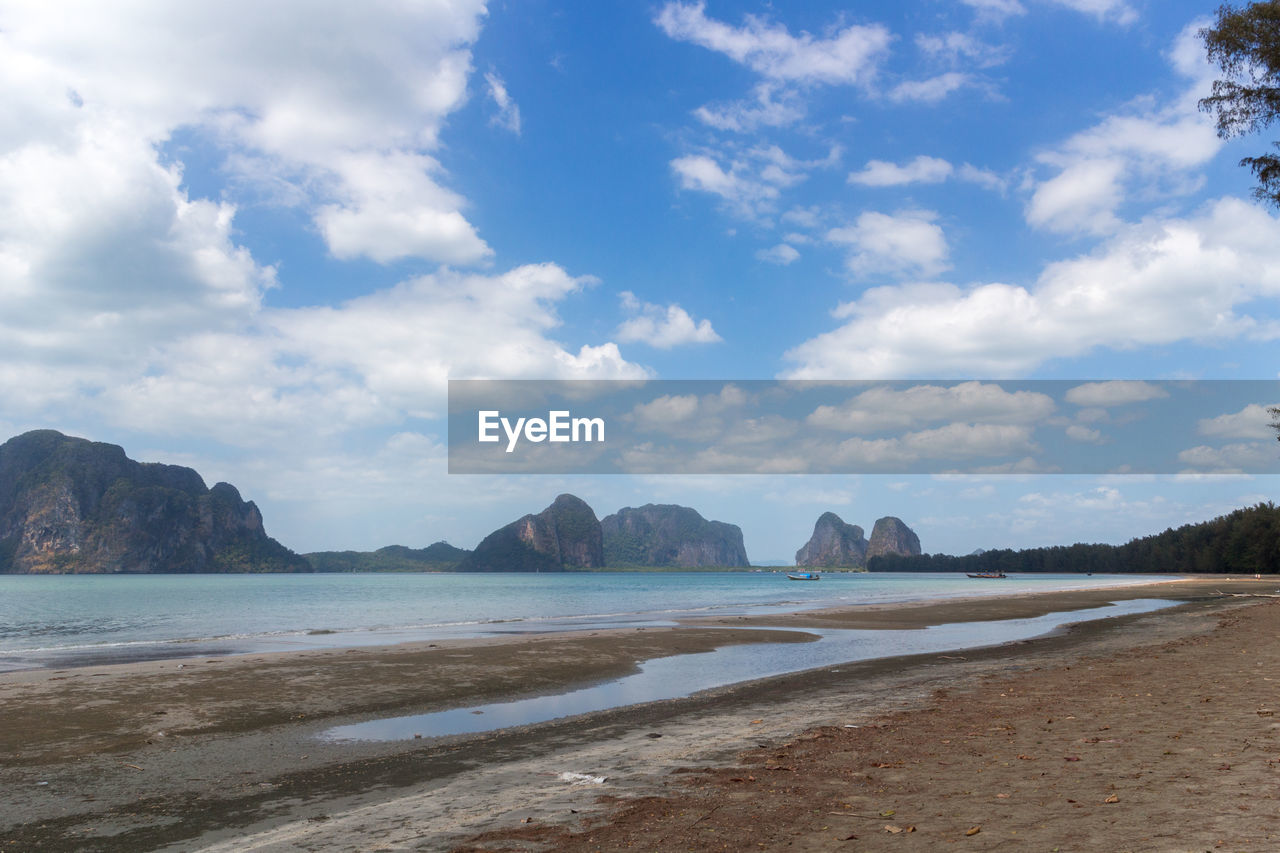 Scenic view of beach against cloudy sky