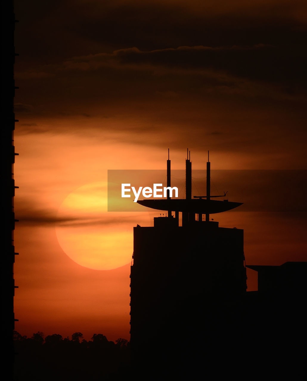 Silhouette buildings against sky during sunset