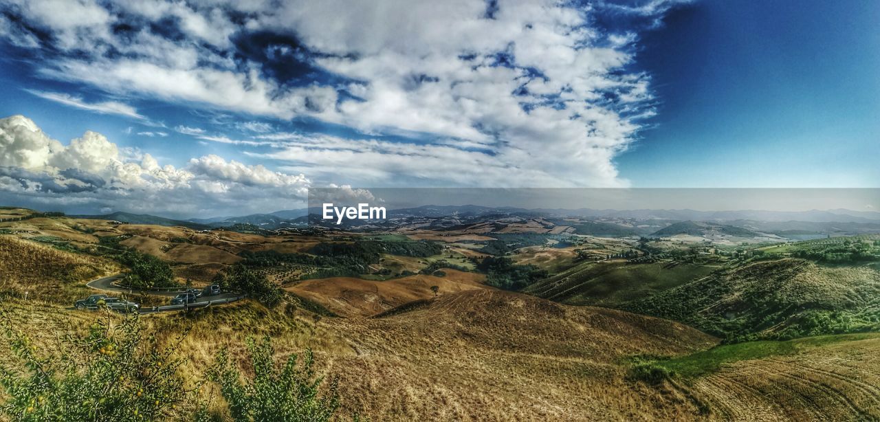 SCENIC VIEW OF MOUNTAINS AGAINST CLOUDY SKY