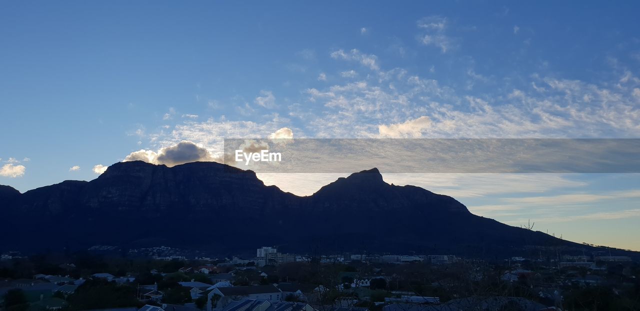 Townscape by mountains against sky