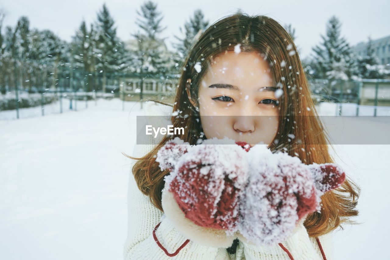 Portrait of cute girl blowing snow
