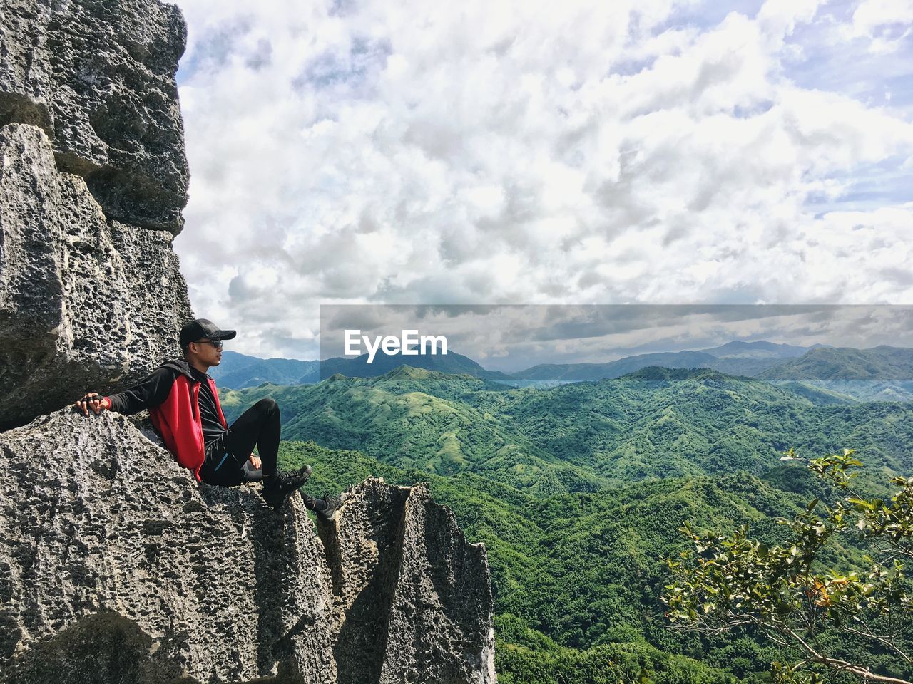 MAN ON ROCKS AGAINST SKY