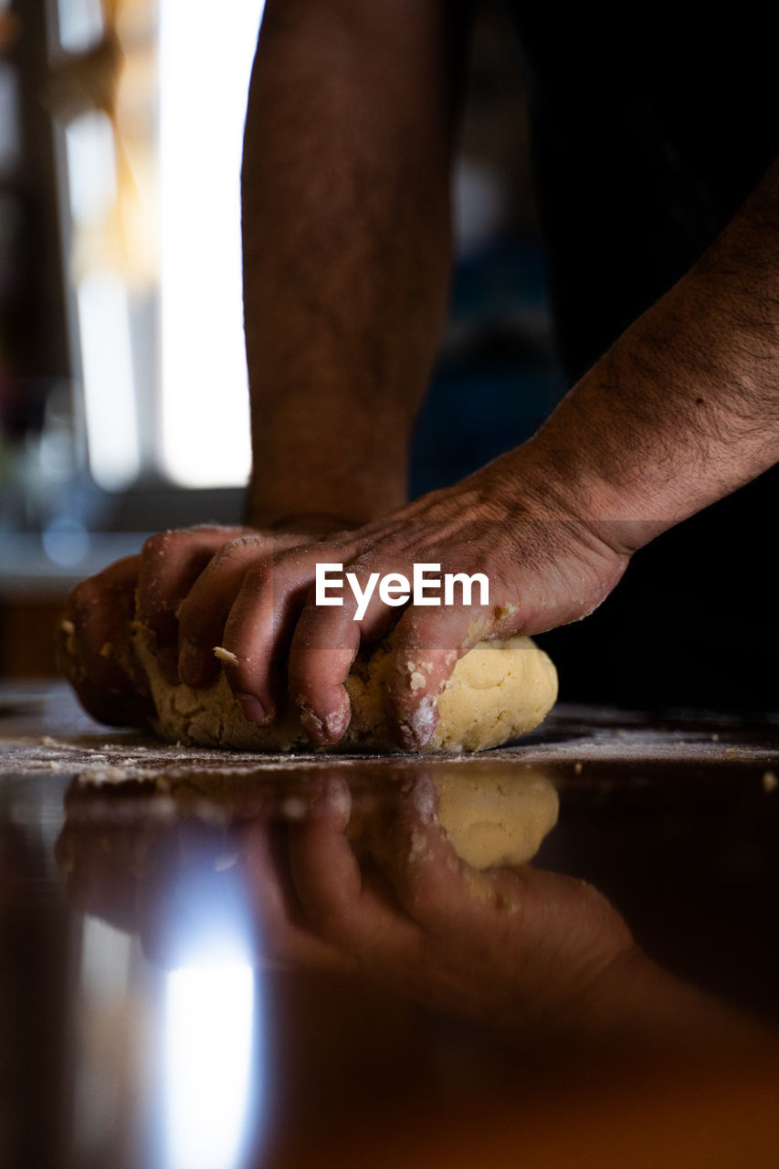 CLOSE-UP OF HAND HOLDING BREAD