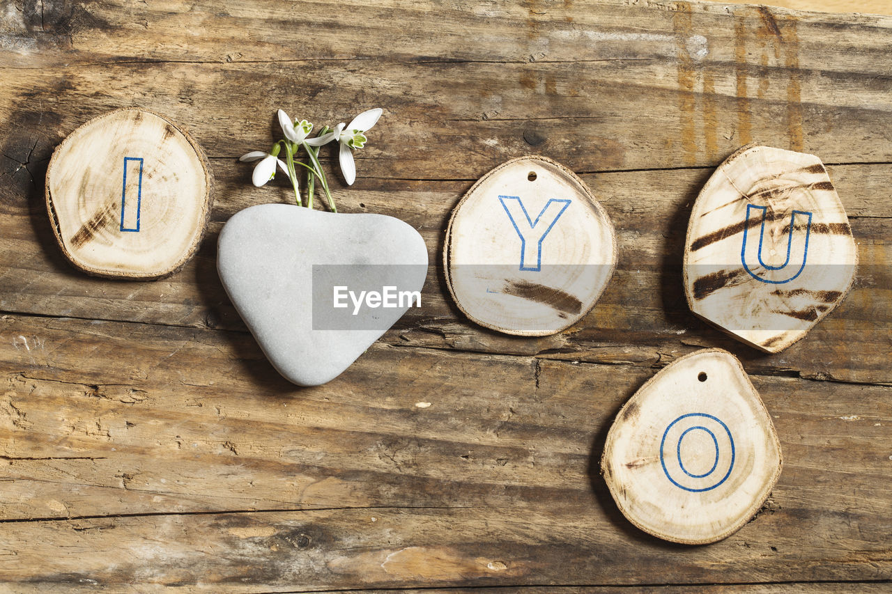 Directly above shot of wood craft and rock on table