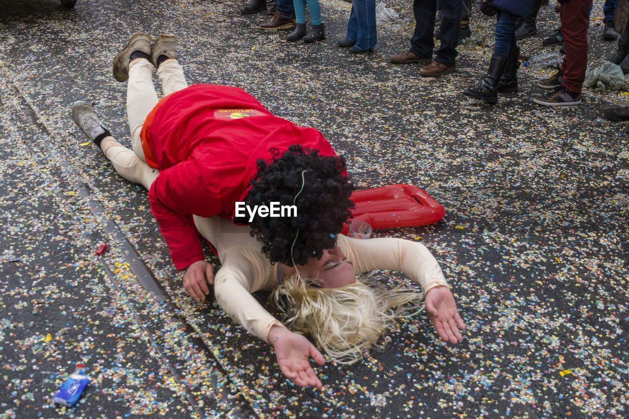 Man kissing woman while lying on road during carnival