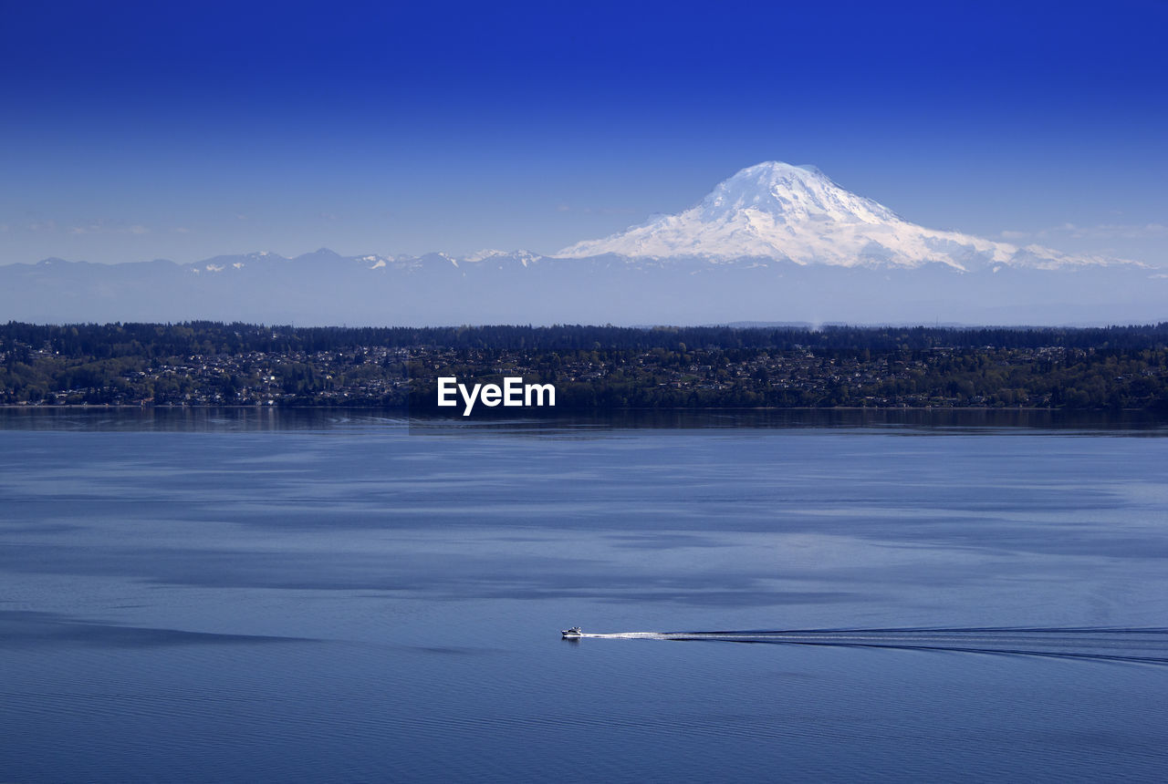 Scenic view of boat in sea against mountain range