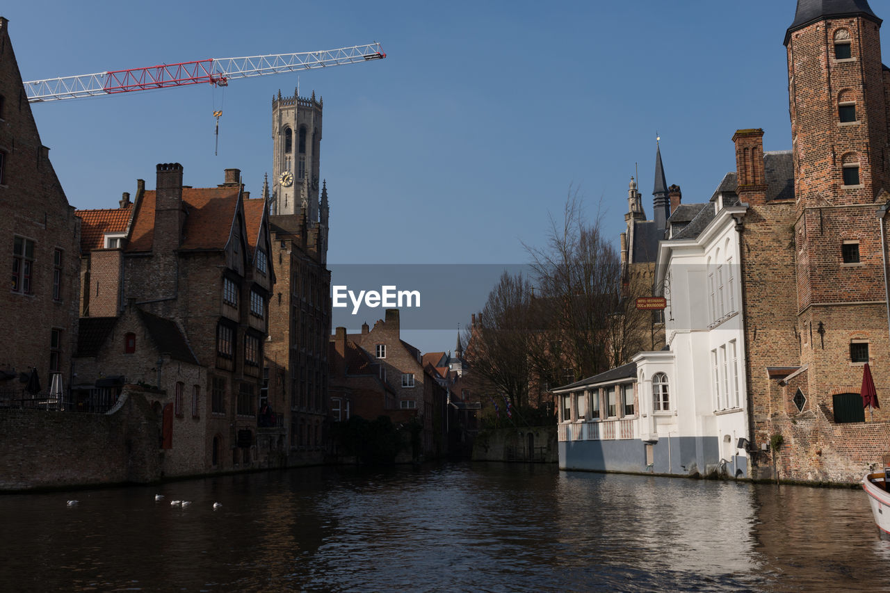View of town by river against sky
