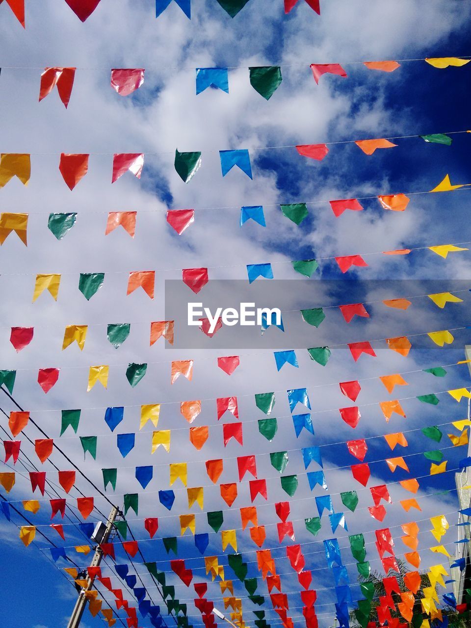 Low angle view of flags hanging against sky