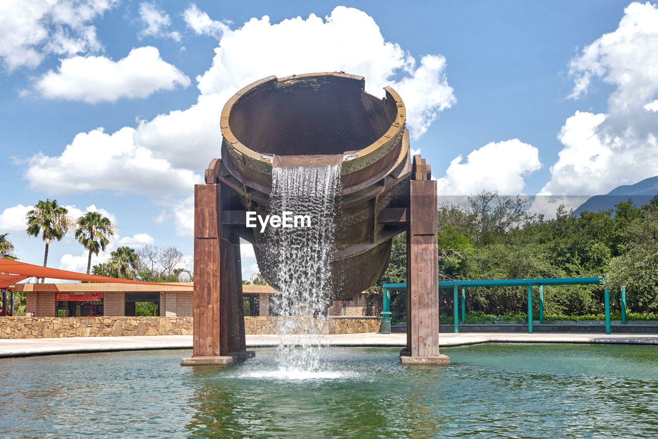 FOUNTAIN IN LAKE AGAINST BUILDING