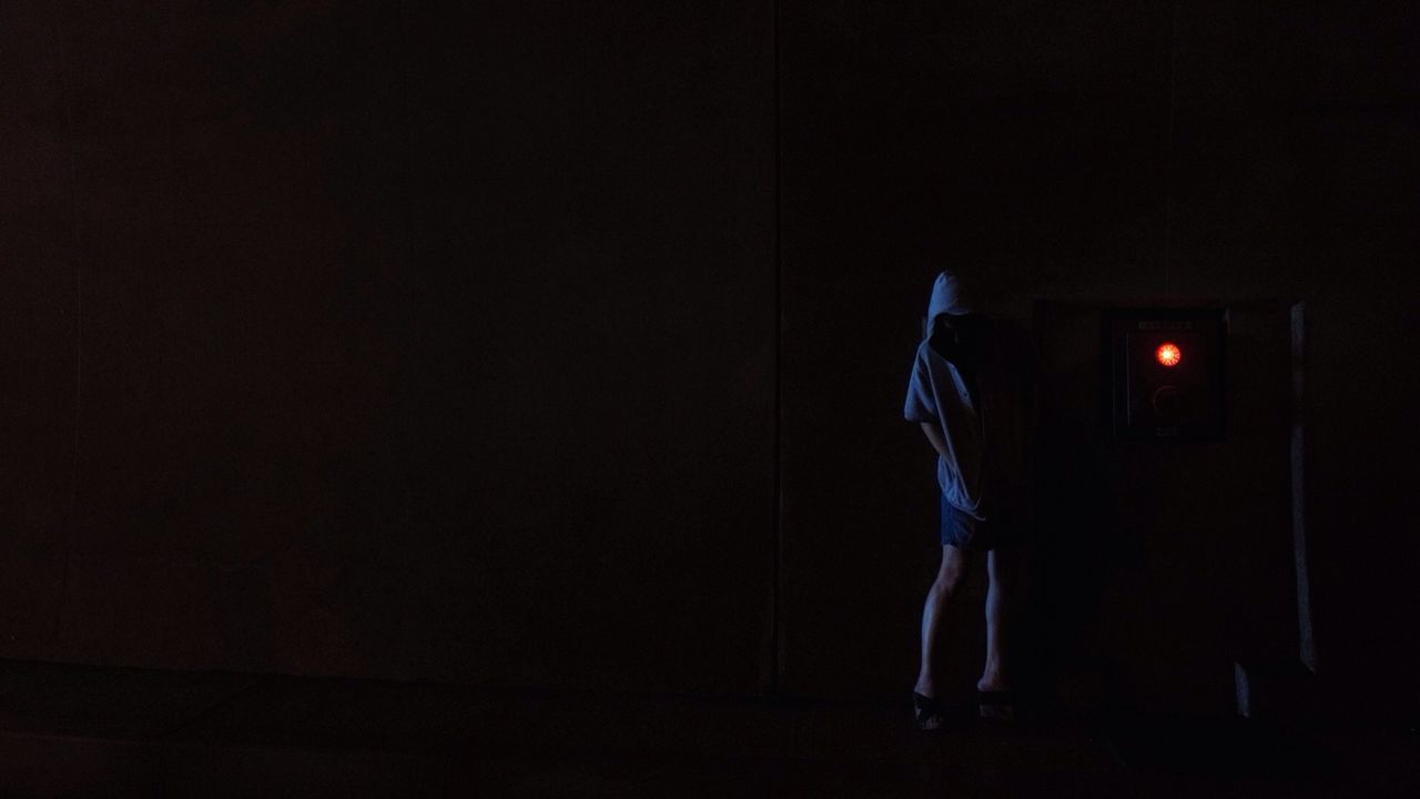 Woman standing in dark room