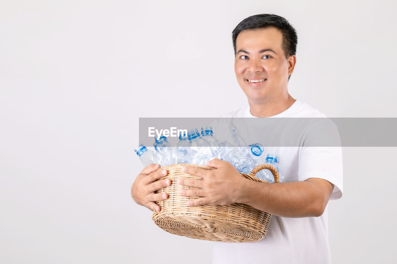 one person, smiling, hand, adult, studio shot, portrait, holding, looking at camera, happiness, arm, person, indoors, finger, men, waist up, cheerful, front view, emotion, business, occupation, clothing, business finance and industry, white background, human head, human face, cut out, casual clothing, young adult, finance, nose, standing, copy space, lifestyles, human mouth