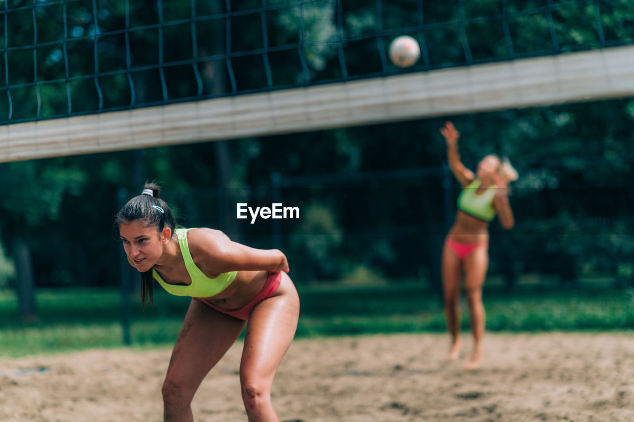 Beach volleyball, female player serving the ball