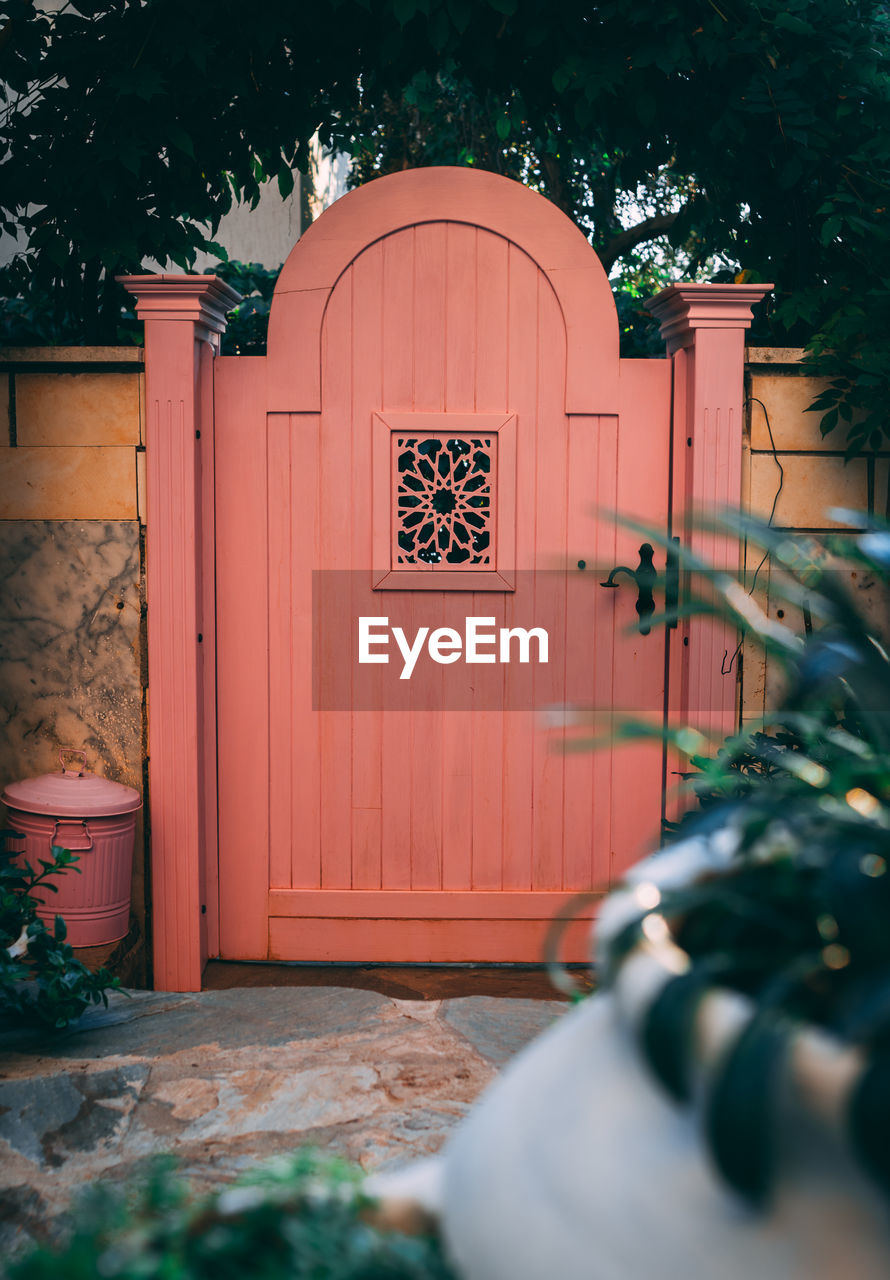 Pink wooden garden gate. perspective view to garden gate.