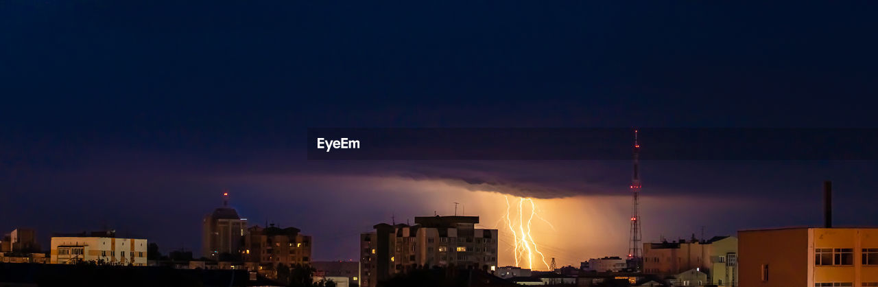 ILLUMINATED CITY AGAINST SKY AT NIGHT