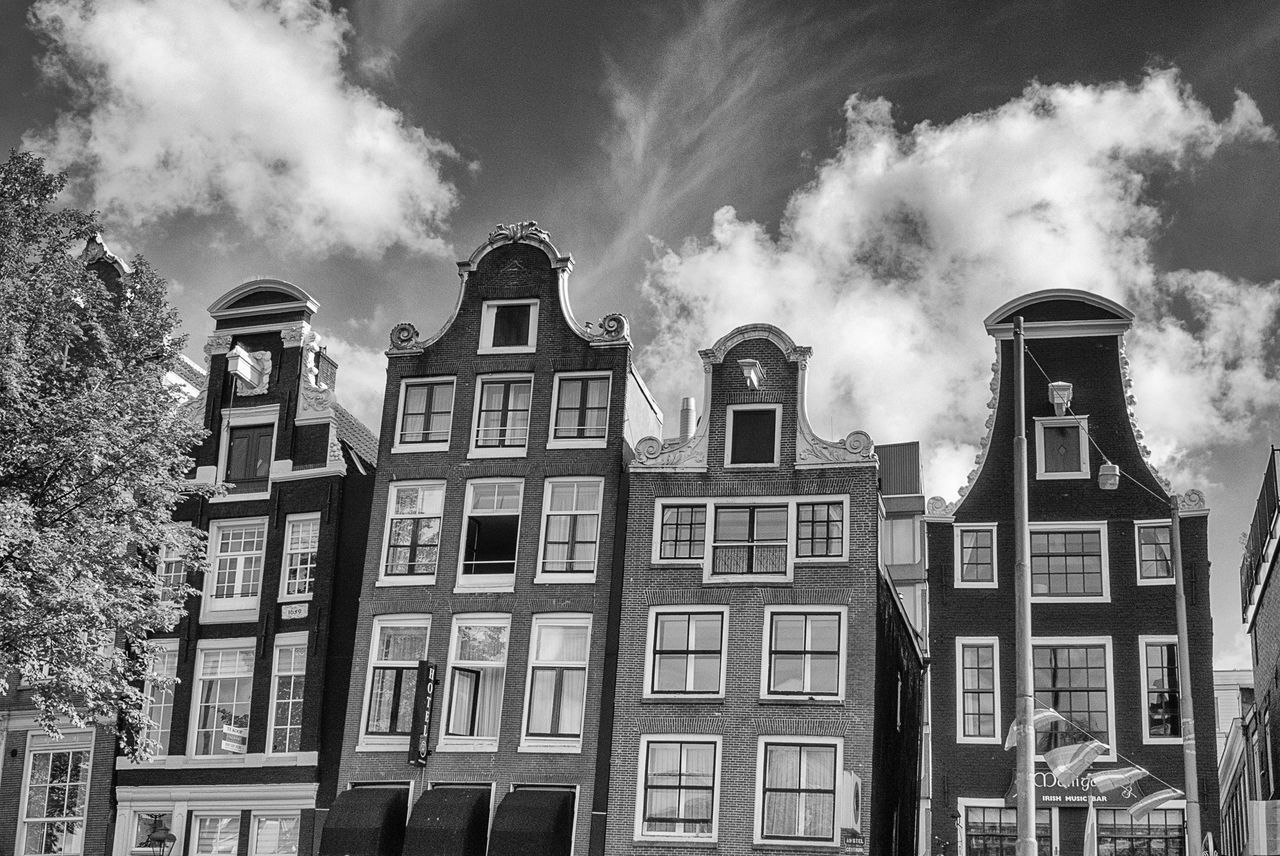 Low angle view of apartments against cloudy sky