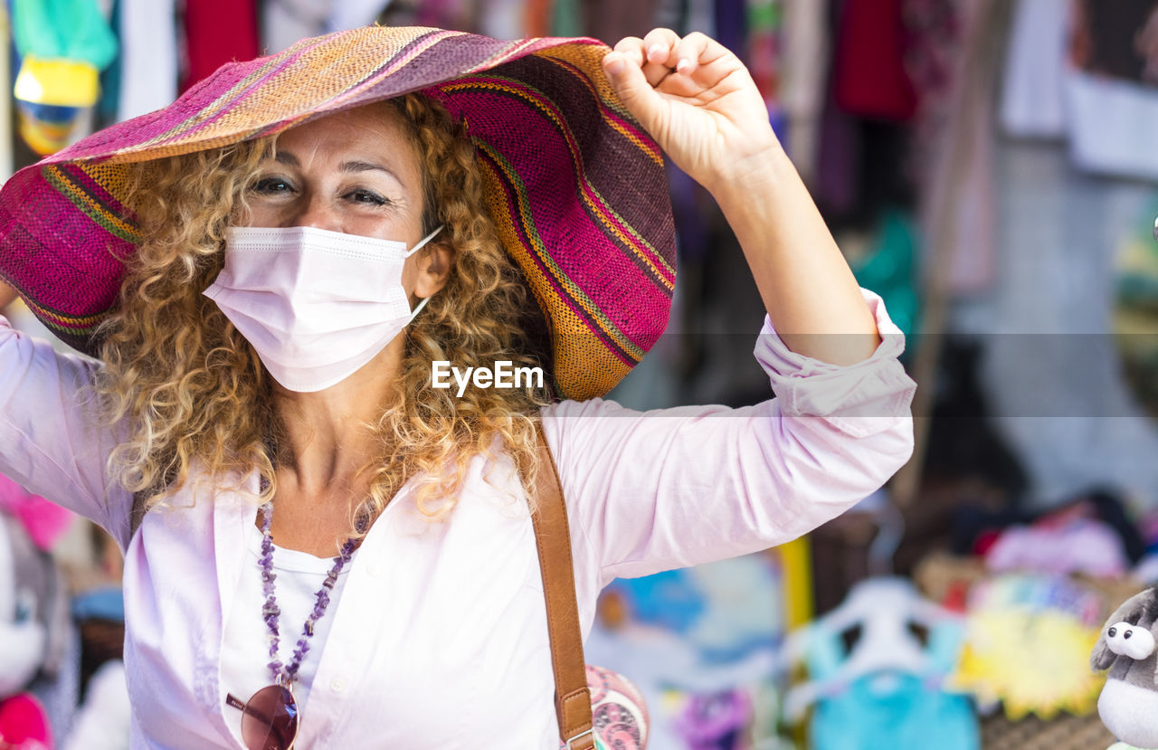 Portrait of woman wearing mask standing at market stall