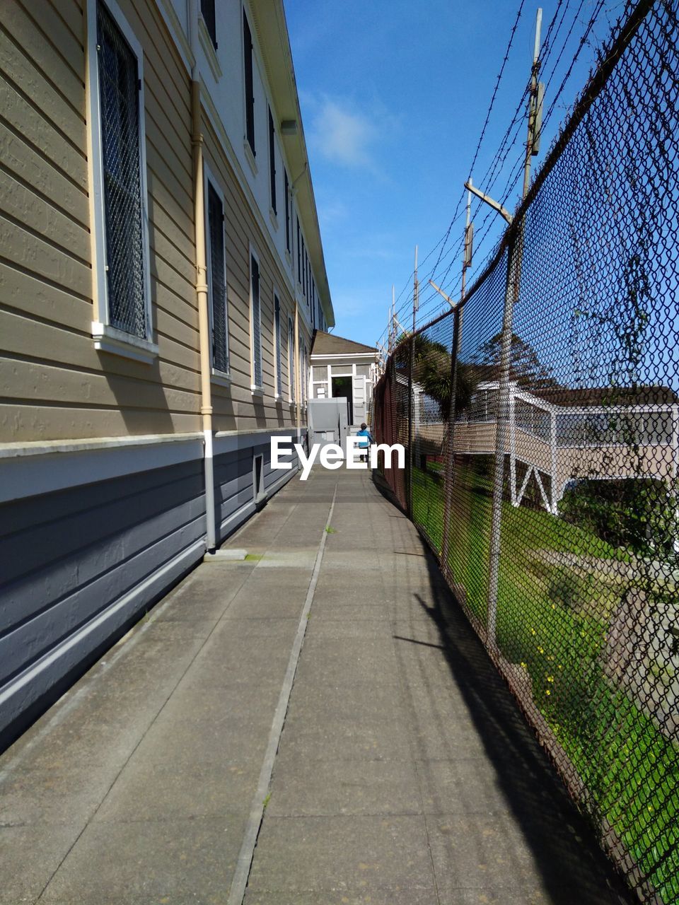 Rear view of boy walking on walkway by building