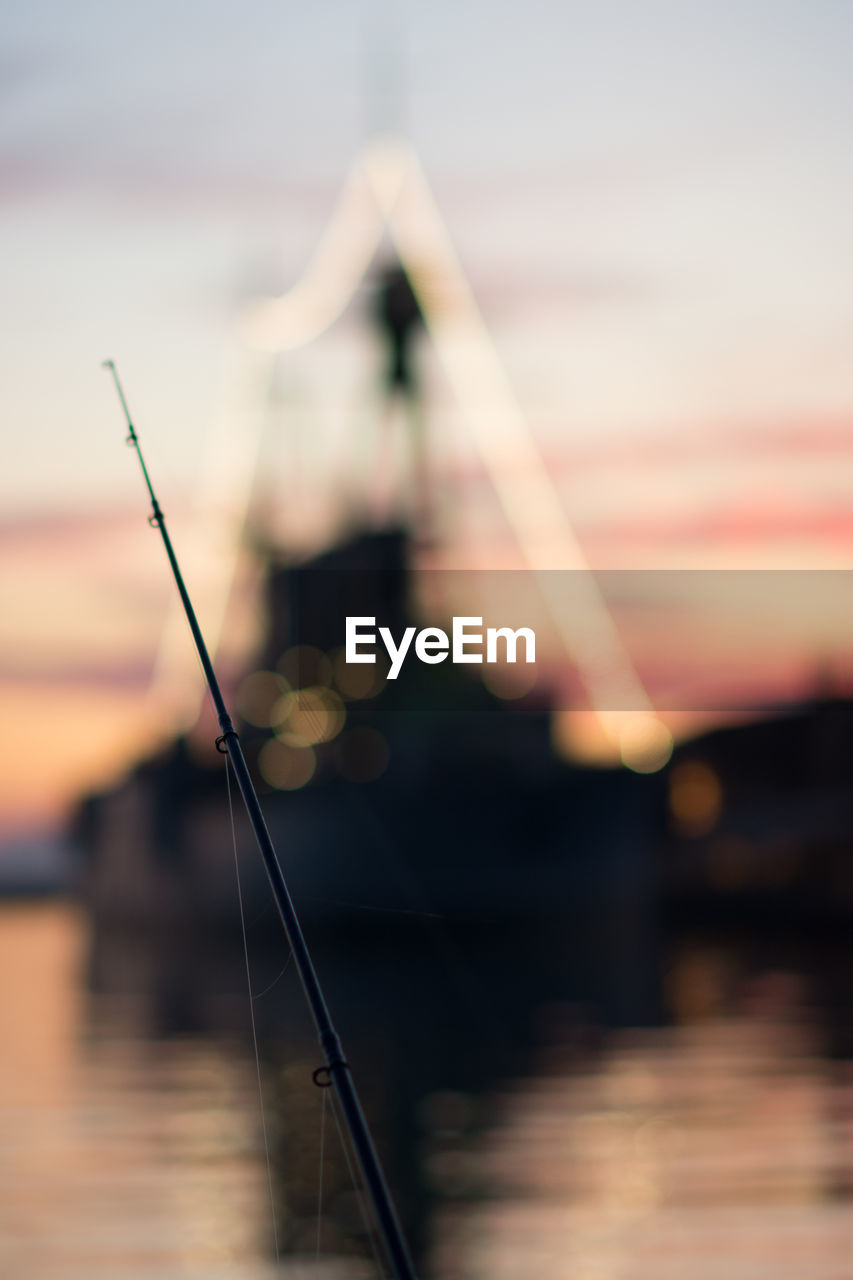 Close-up of fishing rod during sunset
