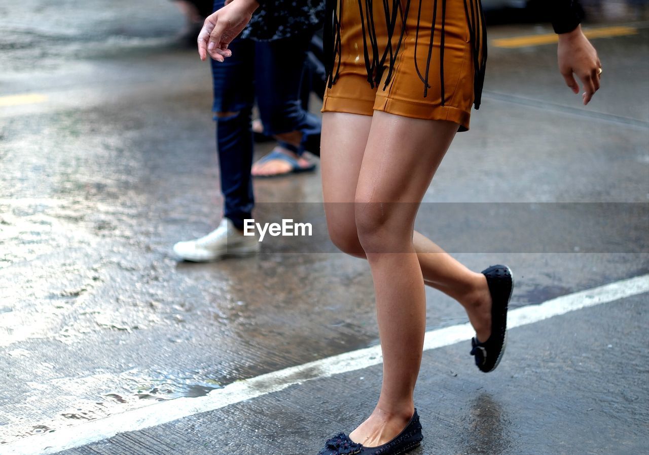 Low section of woman walking on road