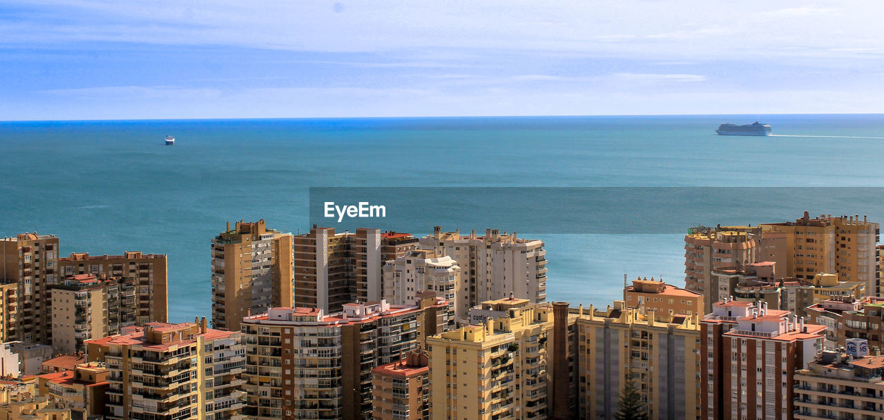 High angle view of buildings by sea against sky