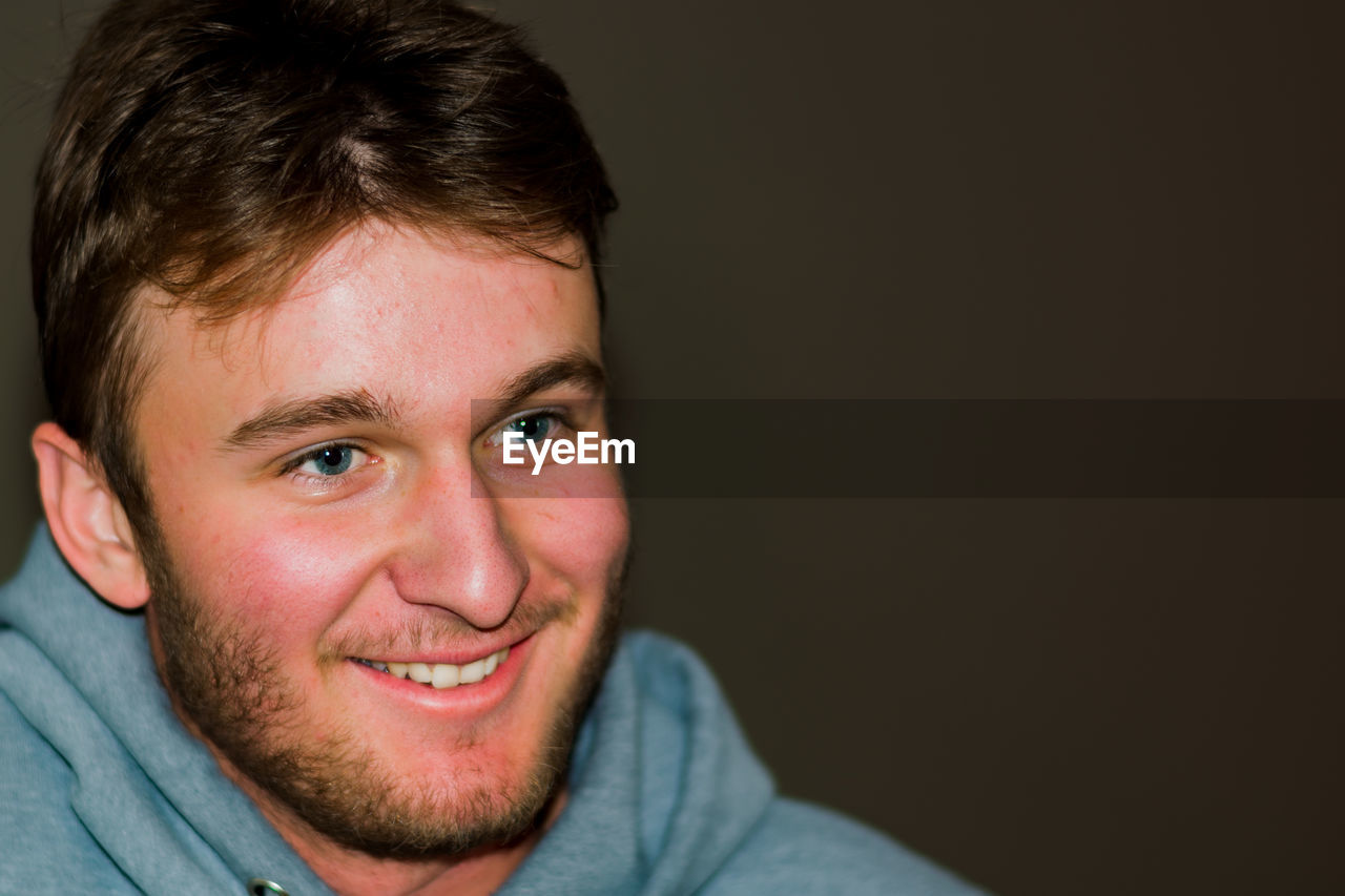 PORTRAIT OF SMILING YOUNG MAN