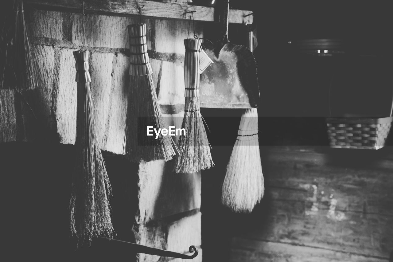 Close-up of brooms hanging in simple house