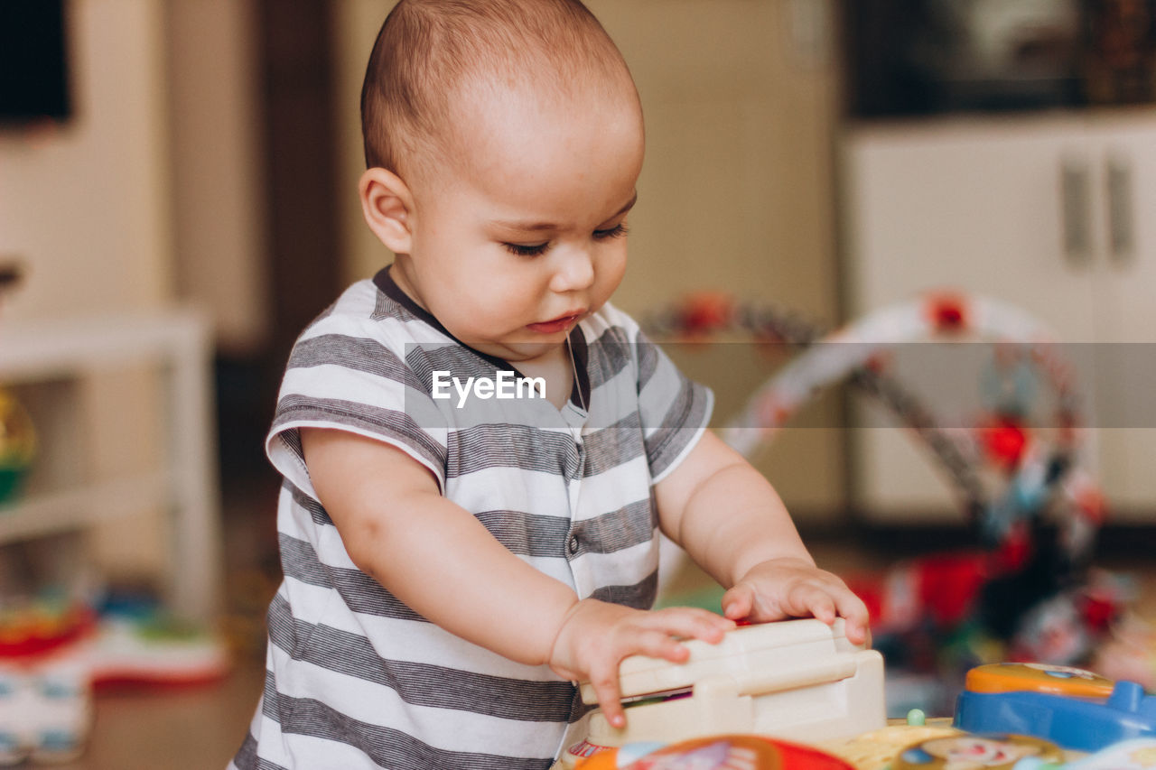 Cute boy playing with toy at home