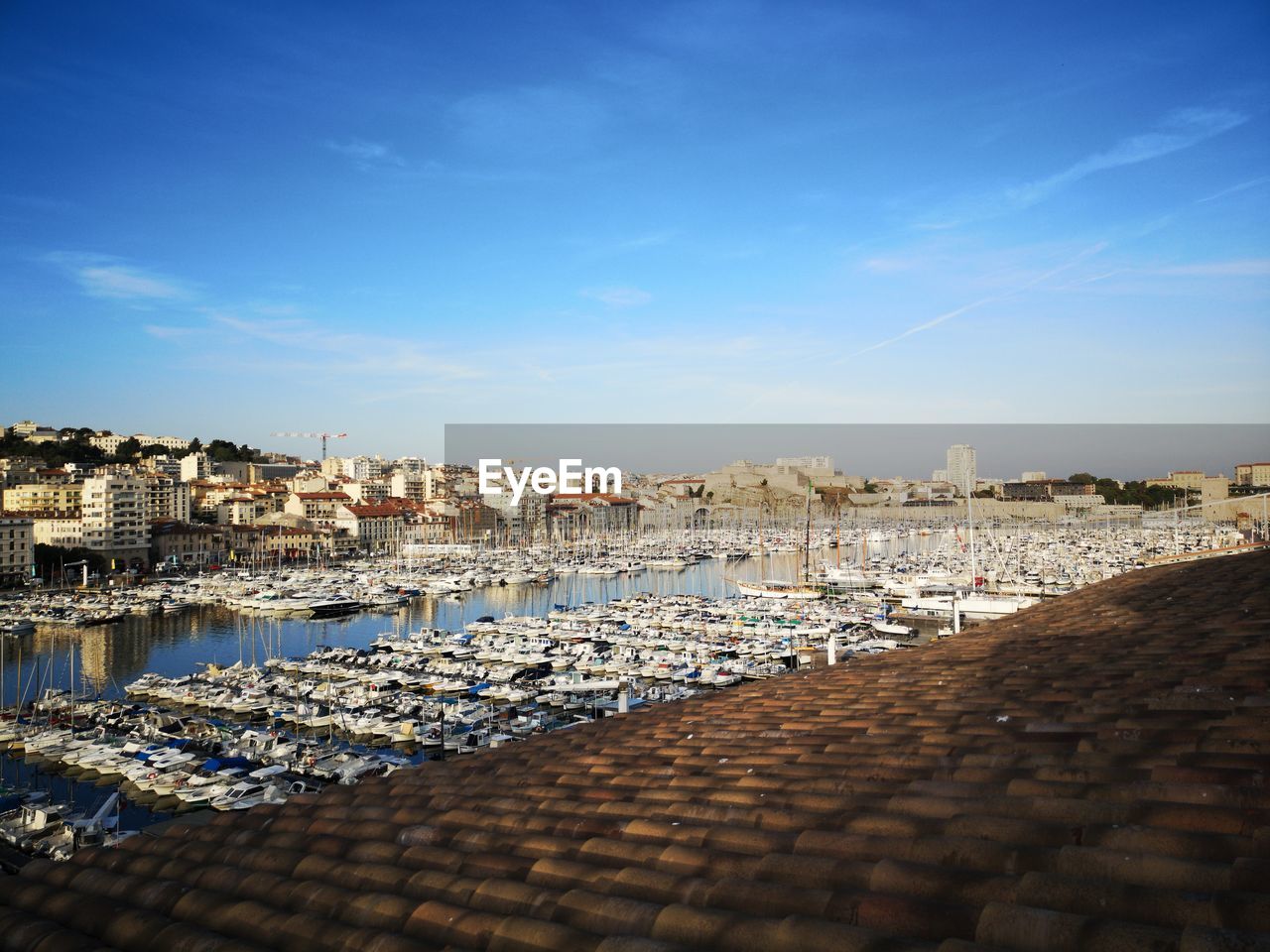 Aerial view of townscape by sea against sky marseille