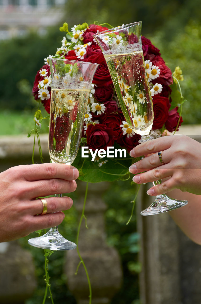 Cropped hands of couple toasting champagne flutes