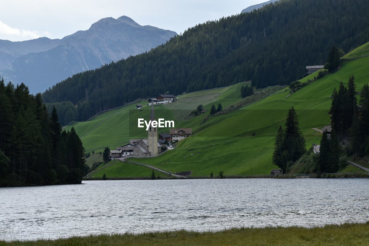 SCENIC VIEW OF GREEN LANDSCAPE AND LAKE AGAINST SKY
